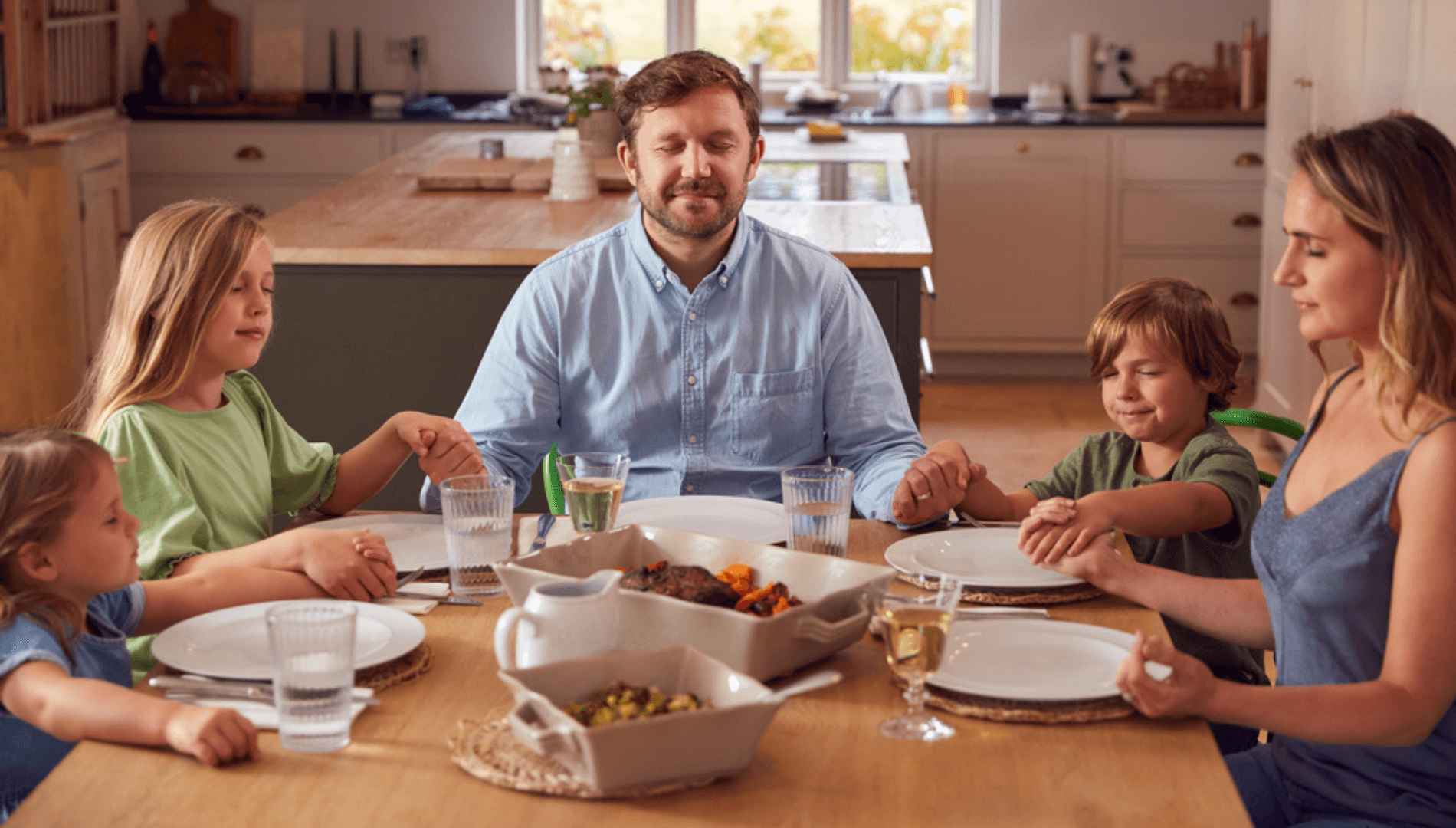 Family of 5 sitting around a dinner table eating