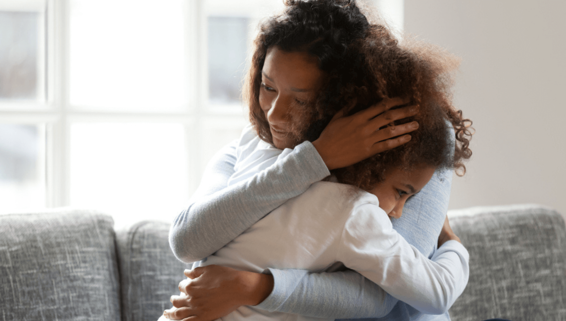 Mother and Daughter hugging on a couch