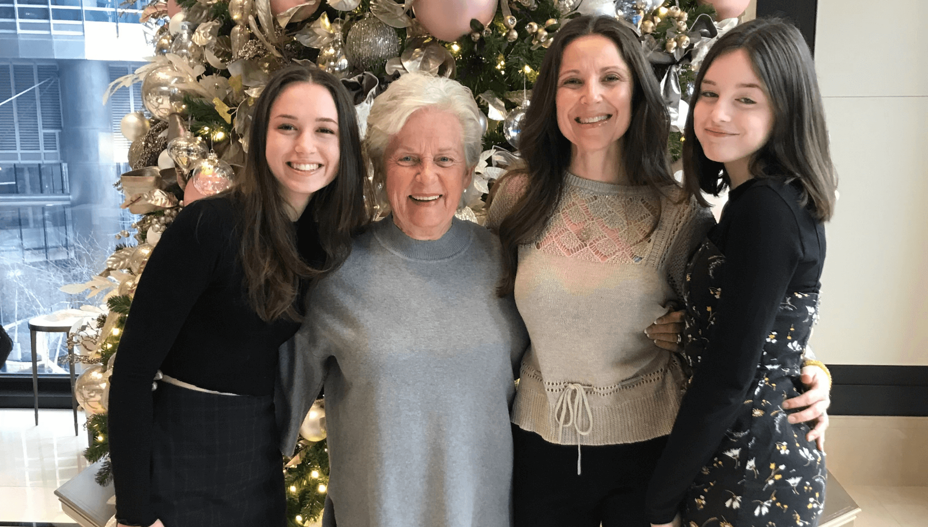 4 women, Mother, daughters and granddaughters infant of a Christmas tree